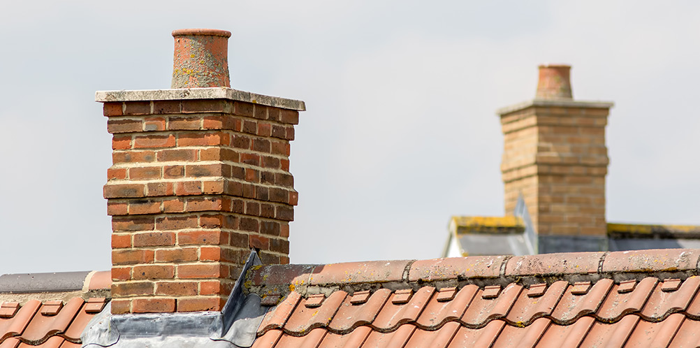 Brick chimney on tiled roof