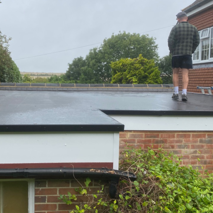 Roofer walking on newly installed flat roof