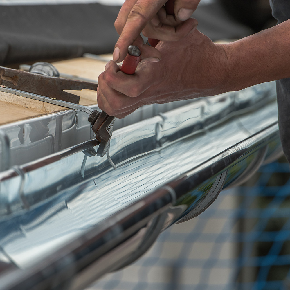 Man installing metal roof gutter