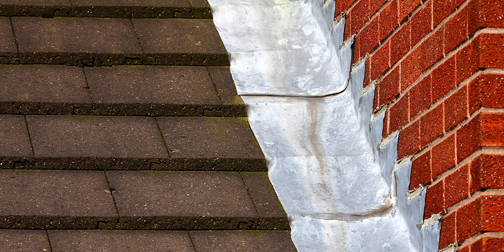 Leadwork attaching tiled roof to brick wall