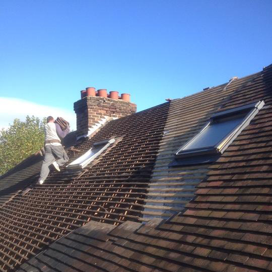 Roofer lifting up tiles to roof installation