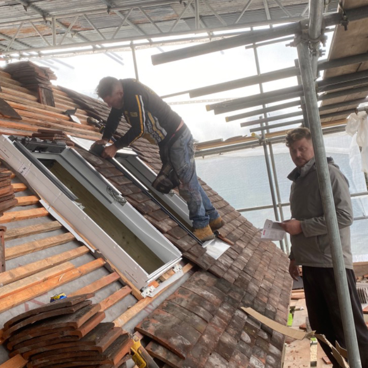 Roofers installing skylight in residential home